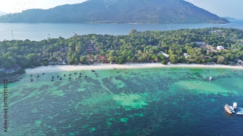 aerial view of beautiful crystal clear water and white sand beach with long tail boats