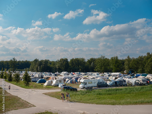 Fotografi Large camping site with numerous tents caravans and blue sky on sunny summer day