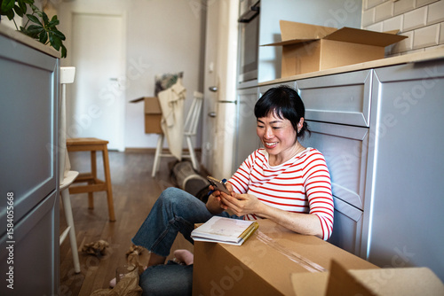 Woman unpacking boxes and organizing kitchen after moving into new home