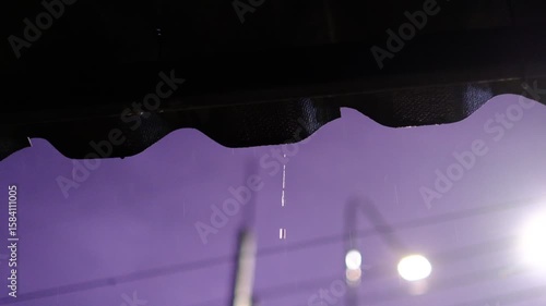 Wallpaper Mural A dark, rainy night with a light shining through the rain. The light is coming from a street lamp, which is visible in the background. The rain is falling heavily, creating a moody atmosphere Torontodigital.ca