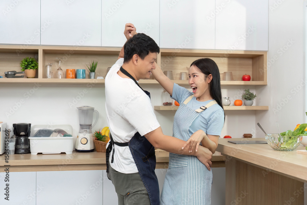 Fototapeta premium Couple Dancing in Kitchen. Celebrating love and joy through movement.
