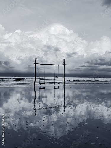Powerful storm clouds gather over the river, reflecting a dramatic sunset landscape on the water