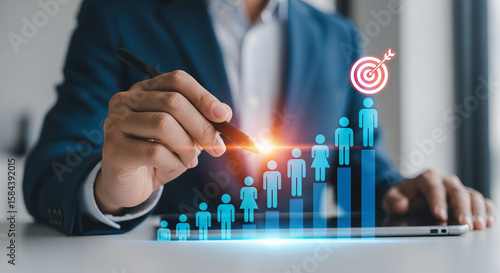 Businessman pointing at growing human figures on a bar chart towards a target
