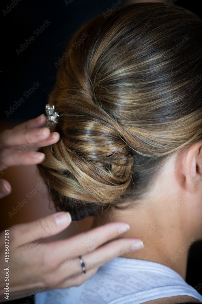Fototapeta premium Stylist Adjusting Elegant Bridal Updo with Hairpin Detail
