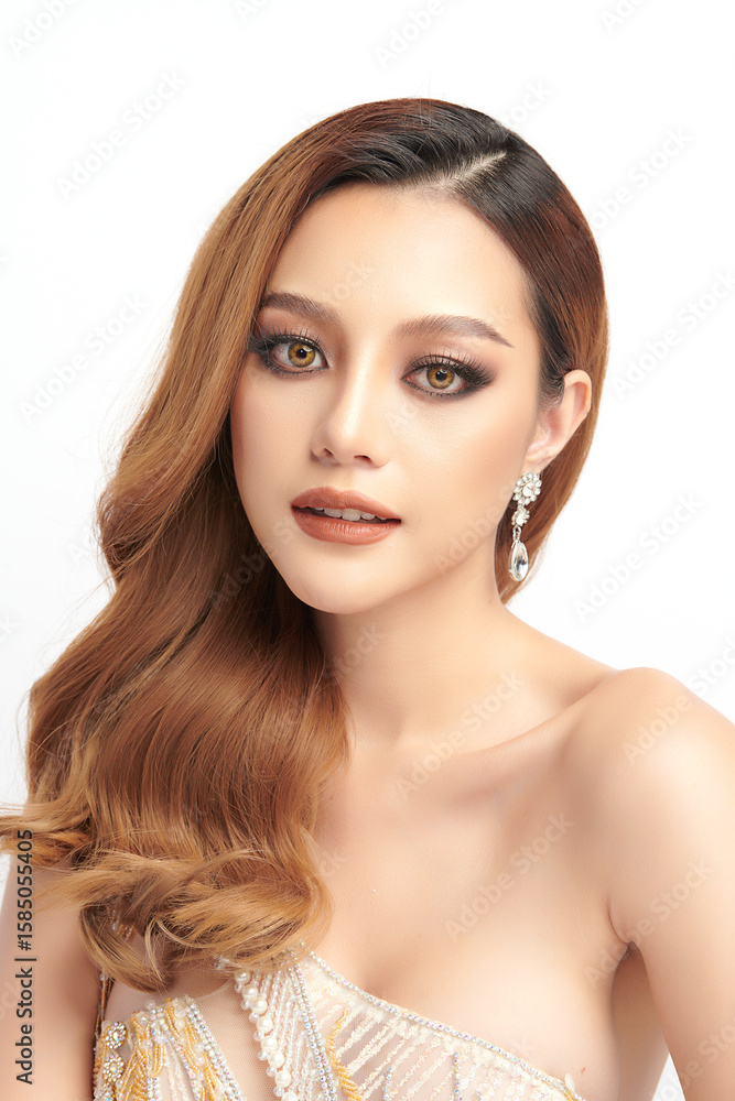 Fototapeta premium A beautiful young Asian woman with clean, fresh skin against a white background. Skincare, facial treatment, cosmetology, beauty, and spa. An elegant portrait of an Asian woman.