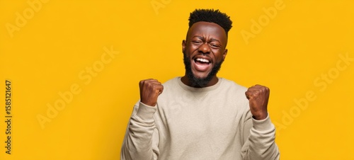 The joyful man celebrating success with enthusiasm against a bright background.