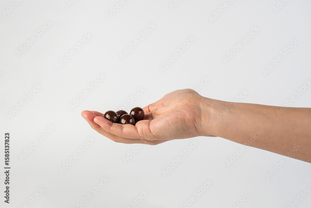 Chocolate ball in hand on white background Chocolate ball in hand on white background