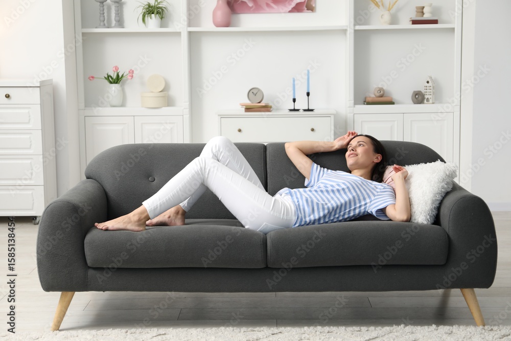 Obraz premium Harmony. Smiling woman lying on sofa at home