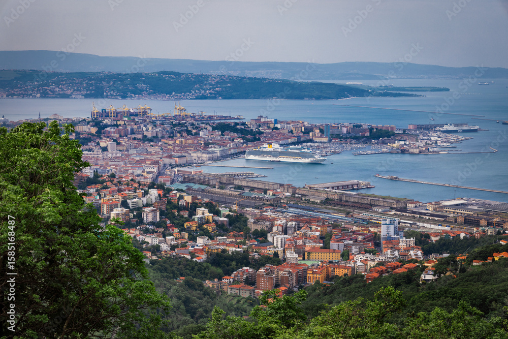 Aerial view of the coastline city where the sea meets the land and buildings, nestled between the mountains and the sea, creating a vibrant and bustling scene, Trieste, Friuli-Venezia Giulia, Italy. Aerial view of the coastline city where the sea meets the land and buildings, nestled between the mountains and the sea, creating a vibrant and bustling scene, Trieste, Friuli-Venezia Giulia, Italy.