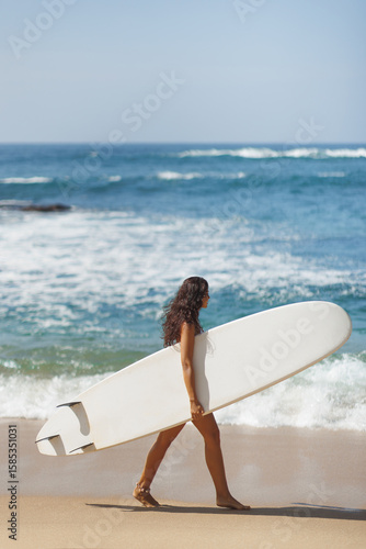 Photography Confident Woman in Bikini Walking on Beach Carrying Long Surfboard