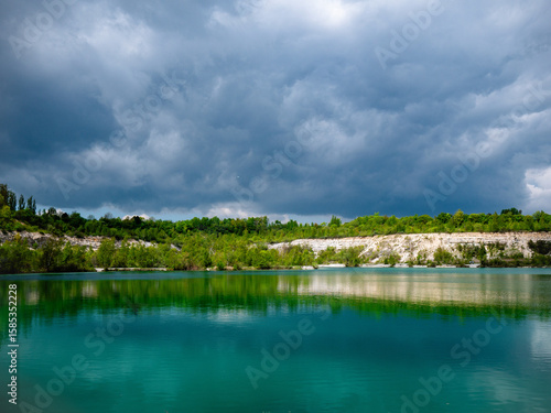 Karlstrup Kalkgrav in Solrød, Denmark—former limestone quarry with turquoise waters, lush greenery, and dramatic skies, perfect for nature, hiking, and geology enthusiasts.