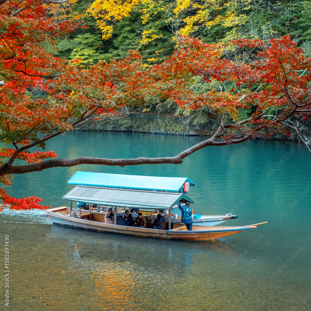 Fototapeta premium Kyoto, Japan - November 18 2024: Unidentified people ride the Hozu River Boat Cruises in Katsura river in Arashiyama district