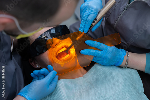 A Dental Procedure in Action: A Patient Receiving Care with Specialized Tools and Protective Equipment in a Modern Dental Clinic Setting