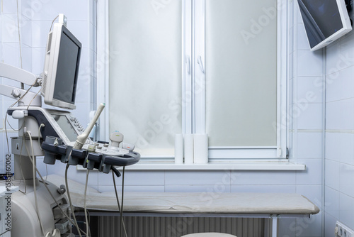 A Clean and Modern Medical Examination Room Featuring Advanced Ultrasound Equipment and Bright Window Space for Patient Comfort and Care