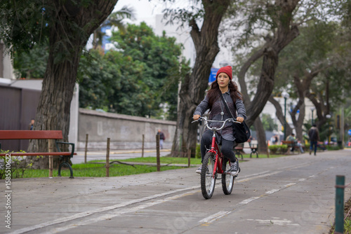 Wallpaper Mural Young woman riding a bicycle through the city park on a cloudy day
 Torontodigital.ca