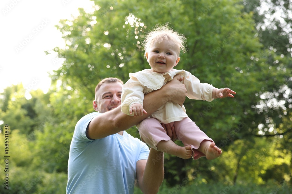 Fototapeta premium Smiling dad and his newborn baby playing outdoors. Happy Father's Day
