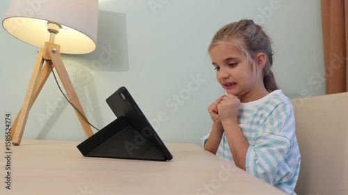 child girl watches videos and communicates on social media on a tablet at home. Generation Z. gadget addiction. 