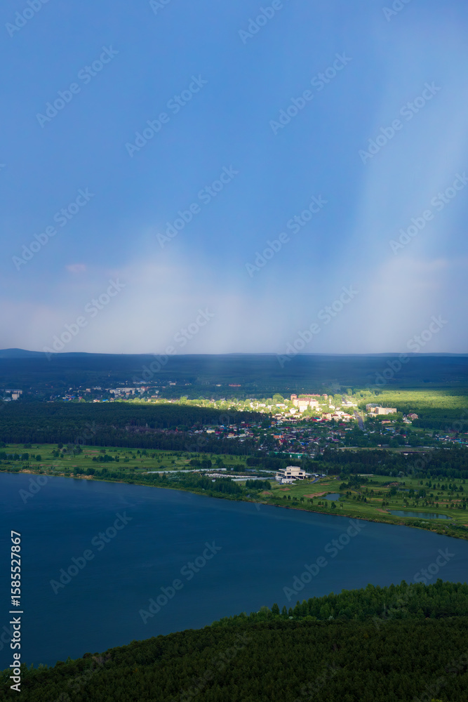 Obraz premium Sunlight shining on village during rainfall