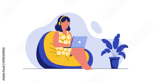 A woman wearing headphones and working on a laptop while sitting on a beanbag chair, with a potted plant nearby, creating a cozy home office environment.