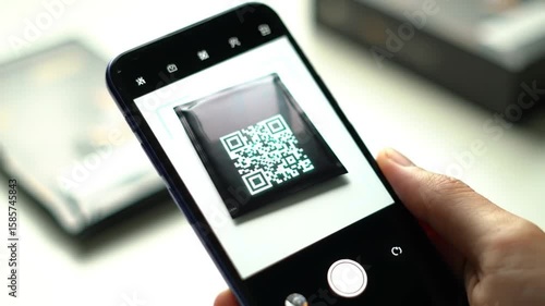 Person holding smartphone and scanning QR code on packaging  