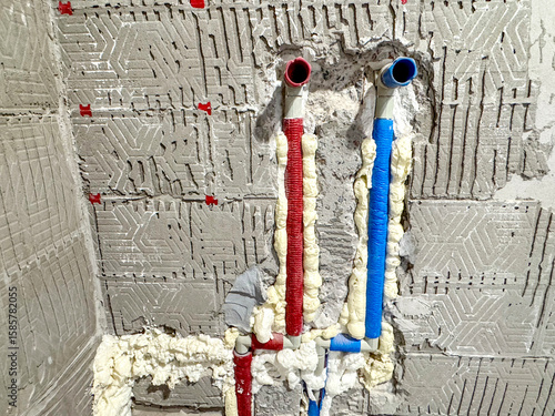 Plastic water supply pipes in blue and red colors installed in floor during apartment renovation. Plumbing, cold and hot water lines, and modern housing infrastructure