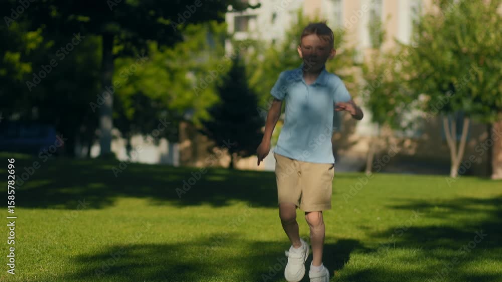 Little kid full of joy running through grass near the school grounds Little kid full of joy running through grass near the school grounds