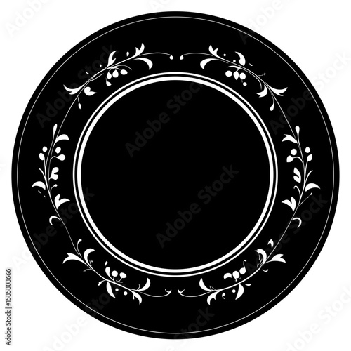 A black circular plate with an ornate white floral vine pattern around the rim
