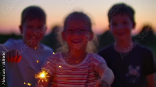 Children playing with sparklers at sunset