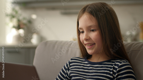 Free Download Caucasian little girl learner schoolgirl child kid offspring daughter using laptop pc computer desktop educate study smile pleasure communication online internet chatting sms technology gadget network - GFXLoad