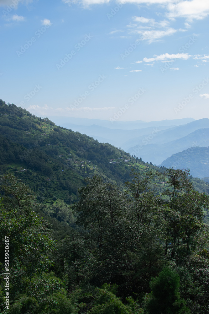 Fototapeta premium Scenic beauty of Green forests of Himalayan mountains, Okhrey, sikkim, India. Okhrey village is remote place in Sikkim where peaceful, tranquil Himalayan mountain range is enjoyed by tourists.
