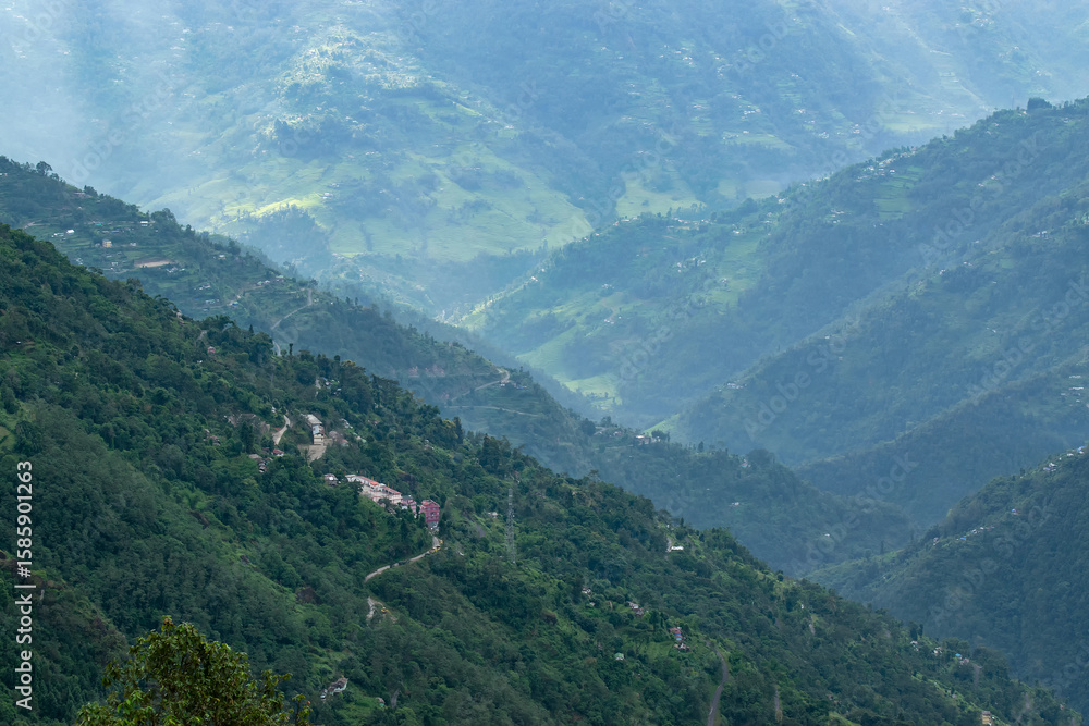Fototapeta premium Sun rays falling on Himalayan mountain range, scenic beauty of layers of mountains, Okhrey, sikkim, India. Okhrey village a remote place in Sikkim where mountain range view is enjoyed by tourists.