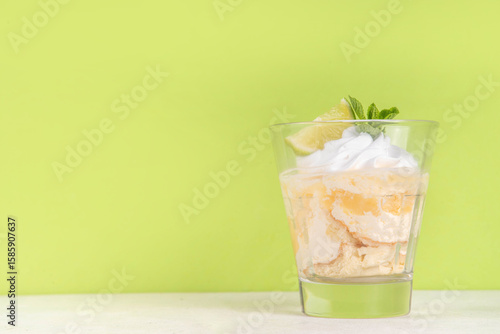 Summer mojito tiramisu dessert, Lime and mint sweet sour taste version of summer tiramisu layered cake with fresh citrus curd, mascarpone and savoyardi. Portion mojito tiramisu parfait dessert