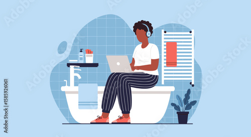 A relaxed woman works remotely on her laptop while comfortably sitting on the edge of a stylish bathtub in a modern bathroom.