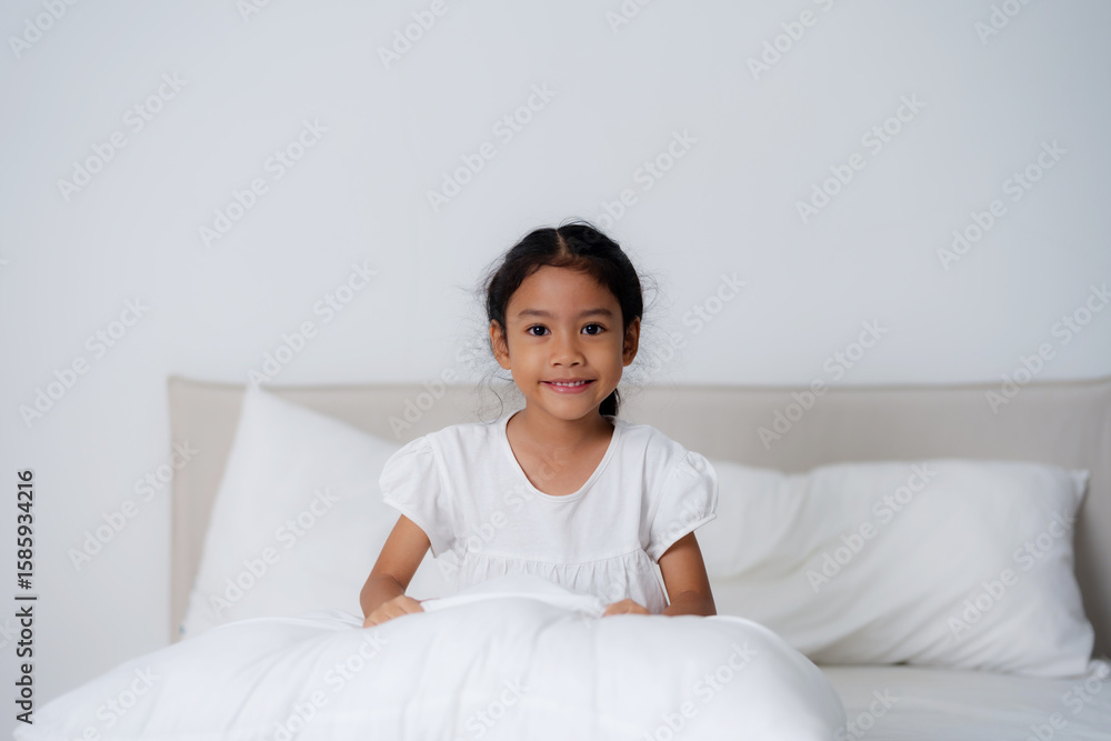 Happy girl hugging pillows on bed in bedroom Happy girl hugging pillows on bed in bedroom