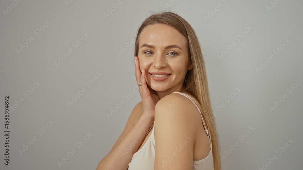 Fototapeta premium Woman smiling confidently against a simple white background, showcasing a bright and positive expression, emphasizing beauty and happiness.