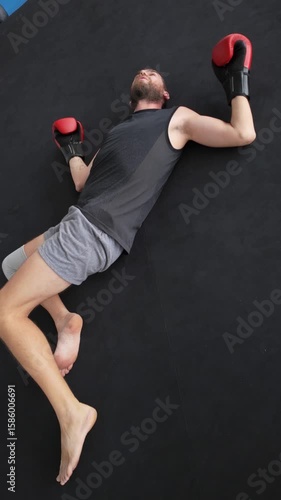 Tired boxer lying on the ring floor after training