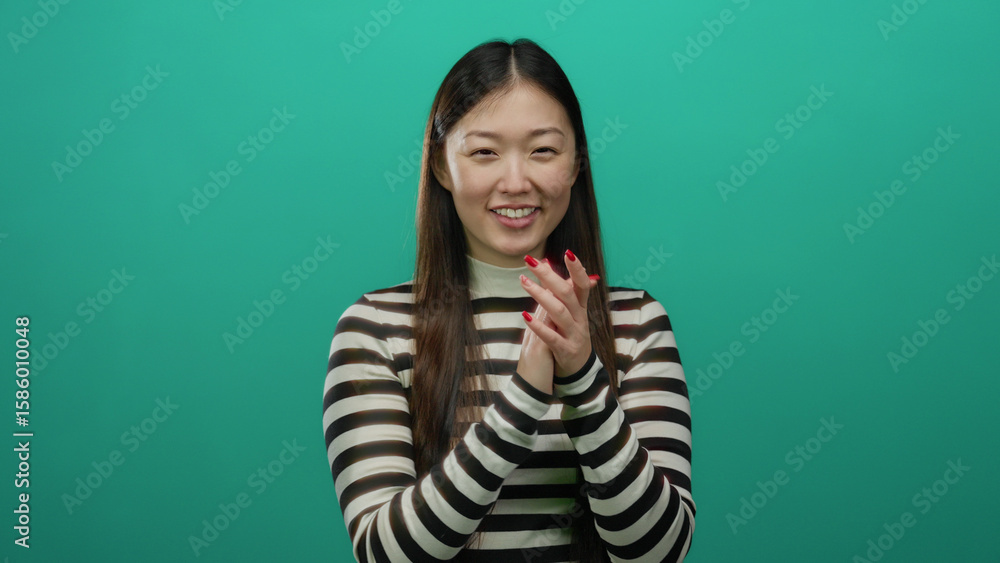 Obraz premium Woman smiling in striped shirt against a vibrant green background showcasing happiness and positivity.