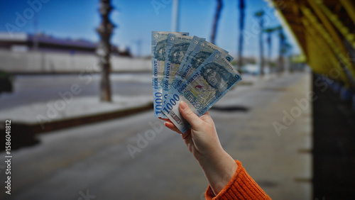Photos Hand holds hungarian forint banknotes outdoors in urban street setting, reflecting business and financial transaction themes in a city environment with natural lighting