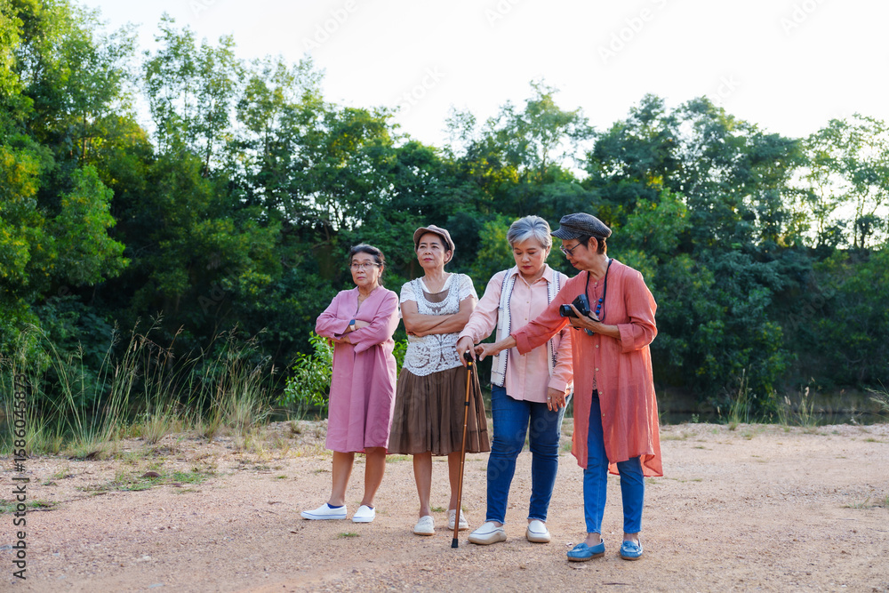 Obraz premium Senior Asian women discussing direction map outdoor nature casual clothing cheerful planning vacation travel adventure freedom leisure lifestyle journey friendship happiness environment sightseeing