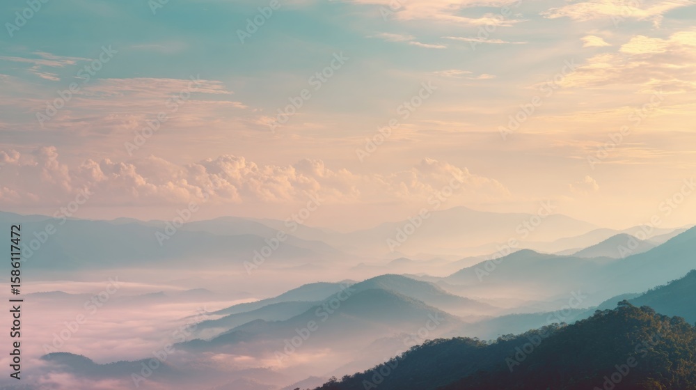 Fototapeta premium Breathtaking panoramic view of misty mountain landscape during sunrise with vibrant sky and clouds.