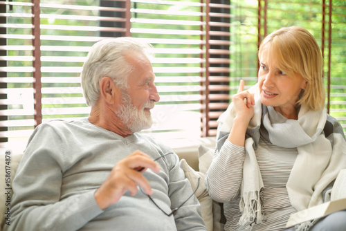 Portrait of middle aged senior couple talking relaxing on comfortable sofa together in living room at home. family relations, taking care concept.