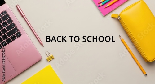 Back to school flatlay featuring a pink laptop, colorful pencils, and a yellow pencil case, ideal for educational content and creative projects, conveying a vibrant learning atmosphere.