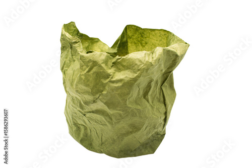 a green paper bag is sitting on a white surface