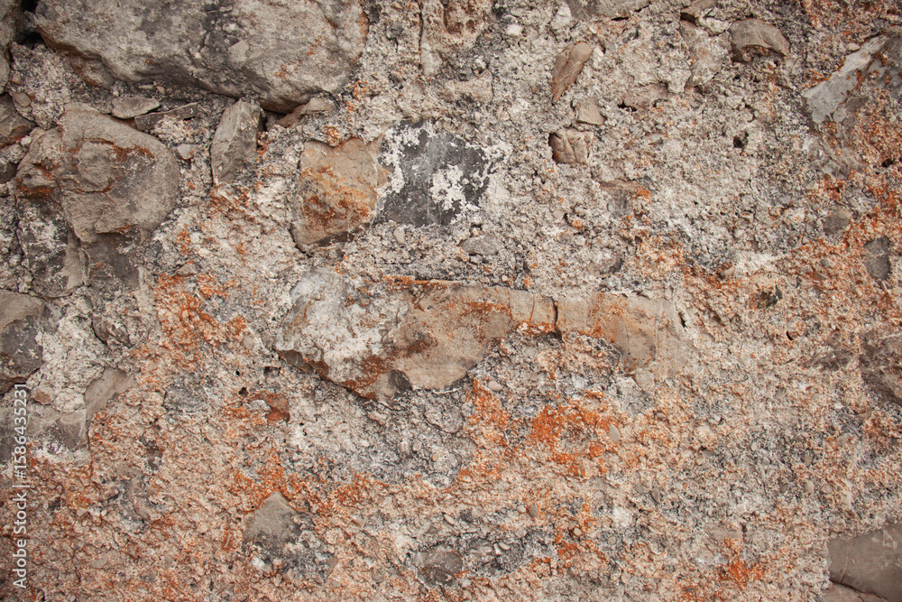 Naklejka premium Close-up of an old rustic stone wall with rough texture and natural earthy tones