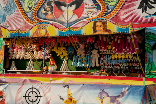 Tableau sur toile Colorful carnival shooting gallery game booth with plush toy prizes and painted