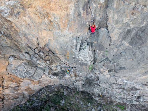 Climbers scaling a natural rock face with equipment