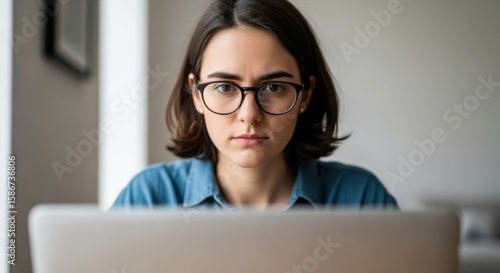 Focused young woman working on laptop at desk
