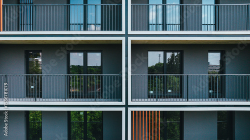 Fotografie Modern apartment building facade with symmetrical balconies and dark tones