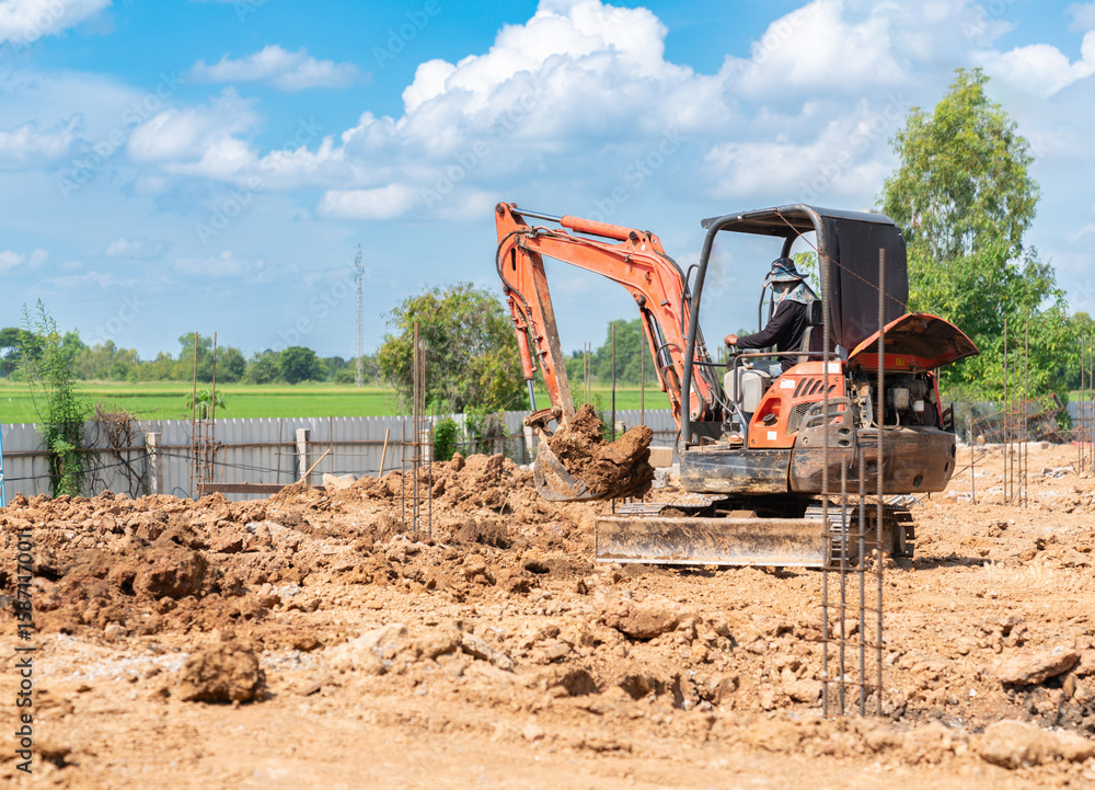 Obraz premium A mini excavator is excavating soil for foundation work at the construction site.