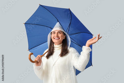 Happy young woman in rainco...